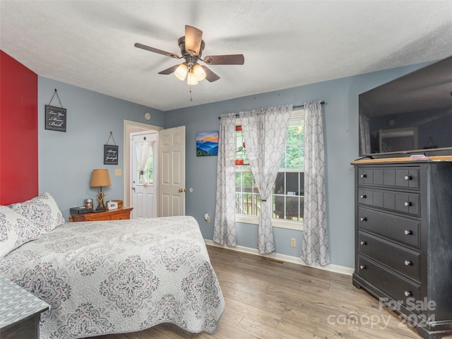 bedroom featuring a textured ceiling, ceiling fan, and hardwood / wood-style floors