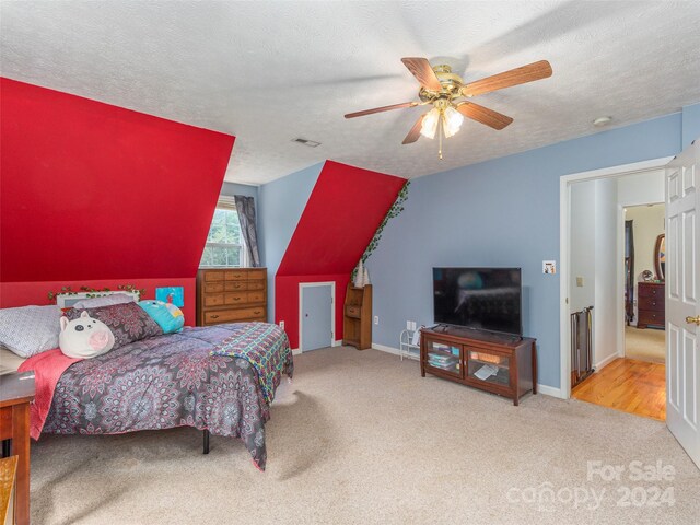 bedroom with light hardwood / wood-style floors, a textured ceiling, and ceiling fan