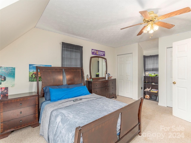 carpeted bedroom featuring a textured ceiling, ceiling fan, and vaulted ceiling