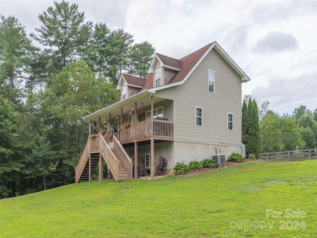 back of property with central AC unit, a lawn, and a deck