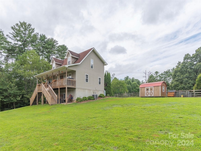 view of yard featuring a wooden deck, central AC unit, and a storage shed