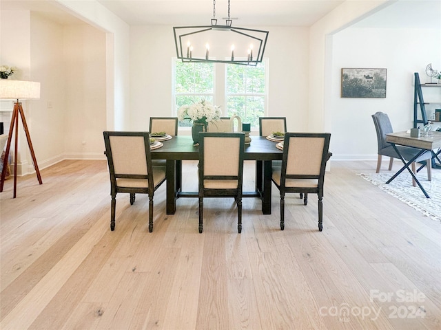 dining area featuring light hardwood / wood-style floors and a notable chandelier