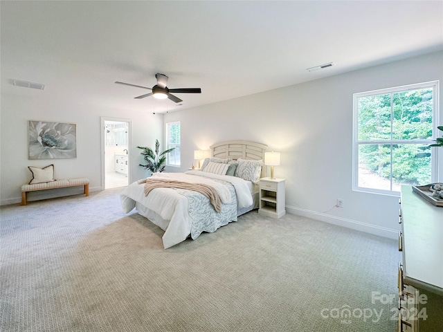 bedroom featuring multiple windows, light colored carpet, and ceiling fan