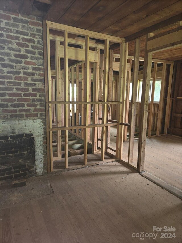 miscellaneous room featuring hardwood / wood-style flooring and brick wall