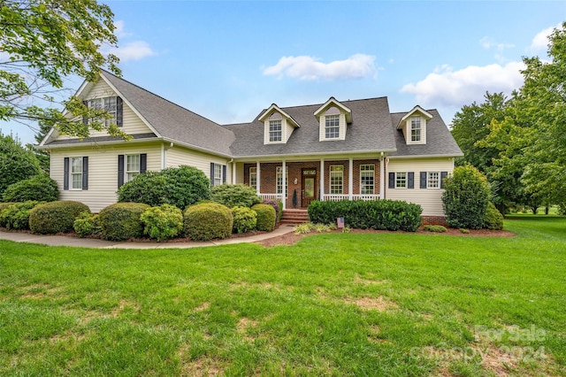 cape cod house with covered porch and a front lawn