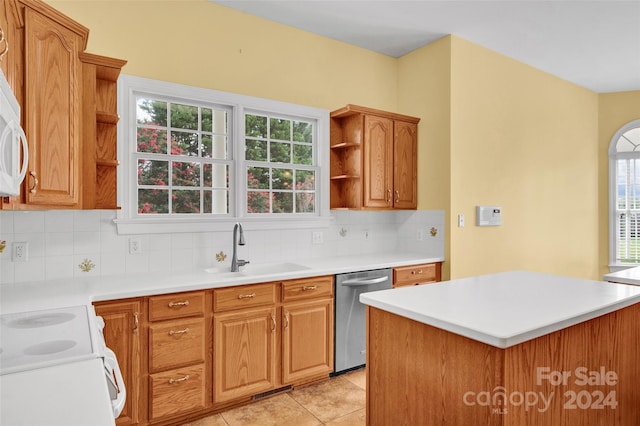 kitchen featuring light tile patterned flooring, dishwasher, tasteful backsplash, and sink