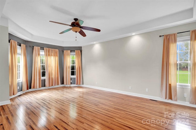 unfurnished room with light wood-type flooring, ceiling fan, and a healthy amount of sunlight