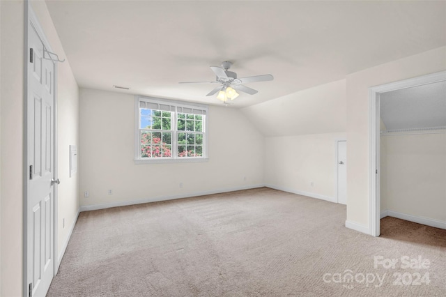 additional living space with lofted ceiling, ceiling fan, and light colored carpet