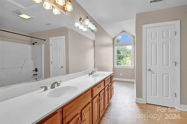 bathroom with lofted ceiling, dual vanity, tub / shower combination, and tile patterned flooring