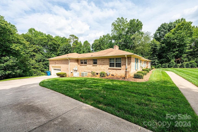 ranch-style home featuring central AC, a garage, and a front lawn