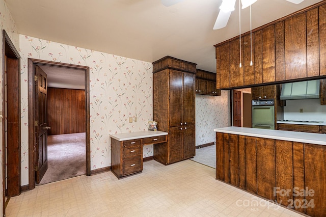 kitchen with ceiling fan, dark brown cabinetry, and oven