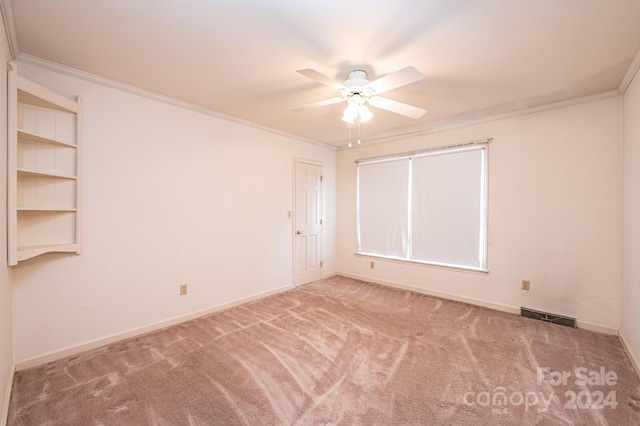 spare room featuring crown molding, carpet floors, and ceiling fan