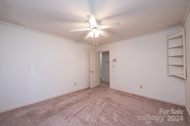 spare room with crown molding, light carpet, and ceiling fan