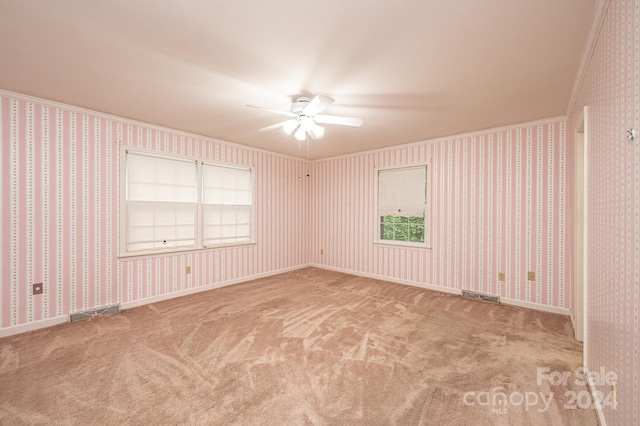 carpeted empty room featuring ornamental molding and ceiling fan