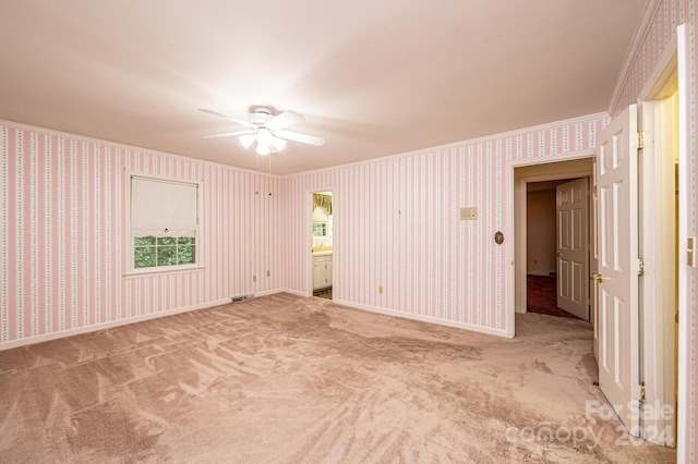 spare room featuring crown molding and carpet