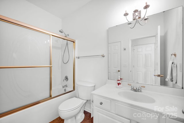 full bathroom with toilet, vanity, bath / shower combo with glass door, and a notable chandelier