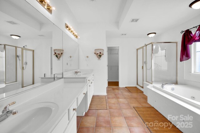 bathroom featuring tile patterned flooring, shower with separate bathtub, and vanity