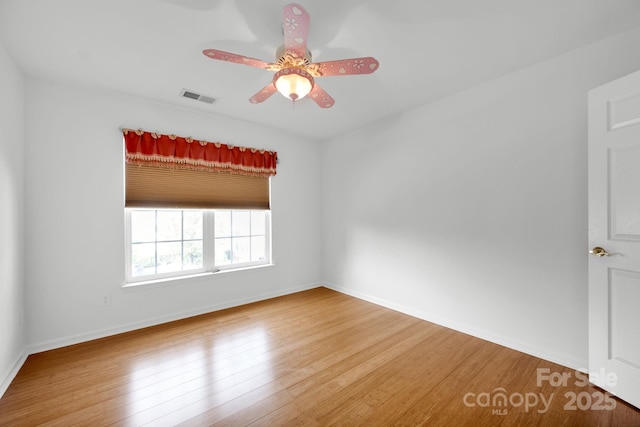 empty room with hardwood / wood-style flooring and ceiling fan