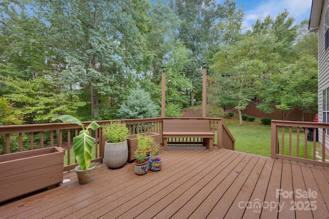 wooden terrace featuring a lawn