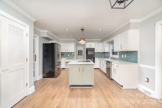 kitchen with stainless steel appliances, light wood-type flooring, a kitchen island, sink, and ornamental molding