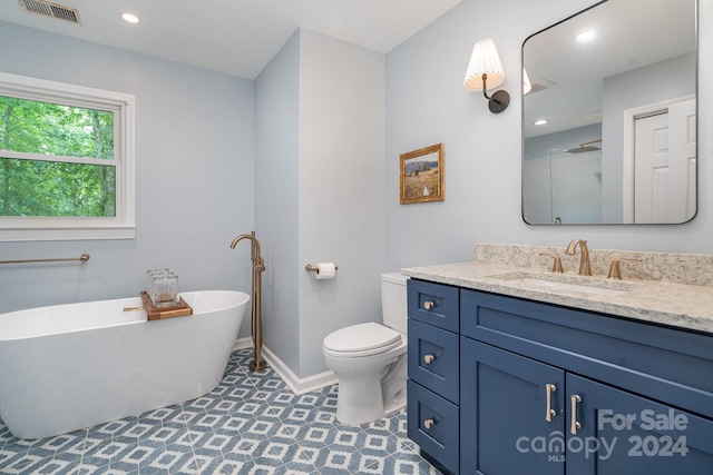 bathroom featuring toilet, tile patterned floors, vanity, and a bathtub