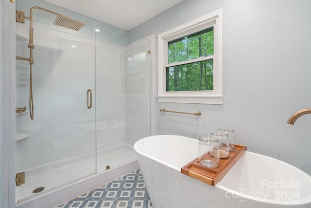 bathroom with wood-type flooring and shower with separate bathtub