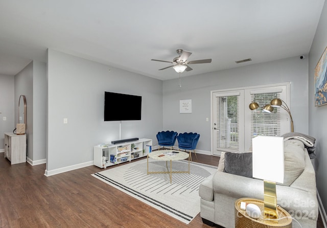 living room featuring ceiling fan, dark wood finished floors, visible vents, and baseboards