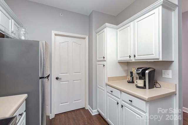 kitchen with dark wood-type flooring, baseboards, white cabinets, light countertops, and freestanding refrigerator