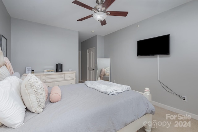 carpeted bedroom with a ceiling fan and baseboards