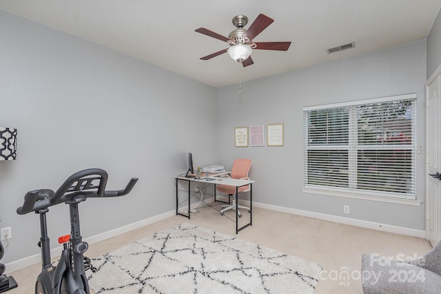 office space featuring visible vents, ceiling fan, light carpet, and baseboards