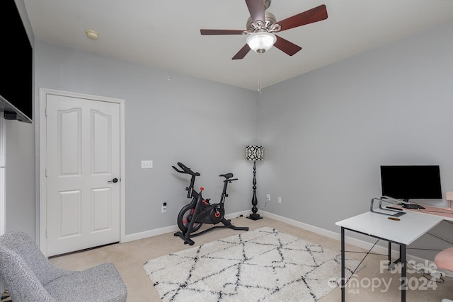 workout area with light carpet, a ceiling fan, and baseboards
