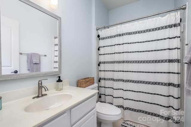 bathroom featuring toilet, vanity, and a shower with curtain
