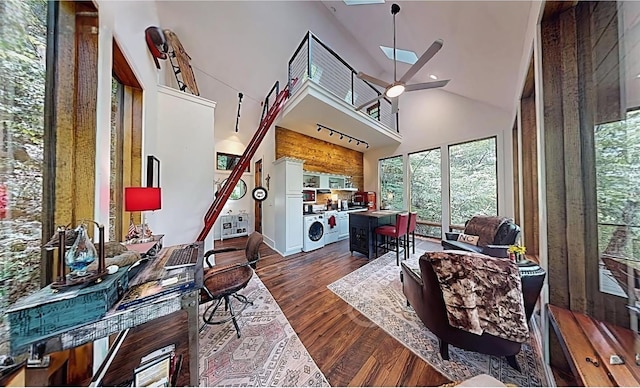 office featuring ceiling fan, track lighting, washer and dryer, dark hardwood / wood-style floors, and high vaulted ceiling