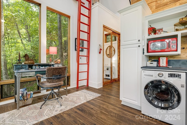 laundry area with dark hardwood / wood-style flooring, cabinets, and washer / clothes dryer