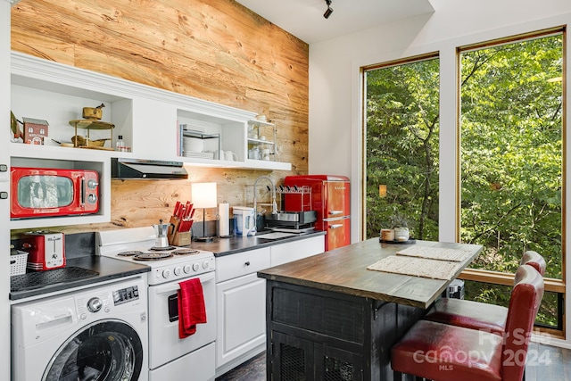 kitchen with white cabinetry, butcher block counters, white range with electric cooktop, a breakfast bar, and washer / clothes dryer