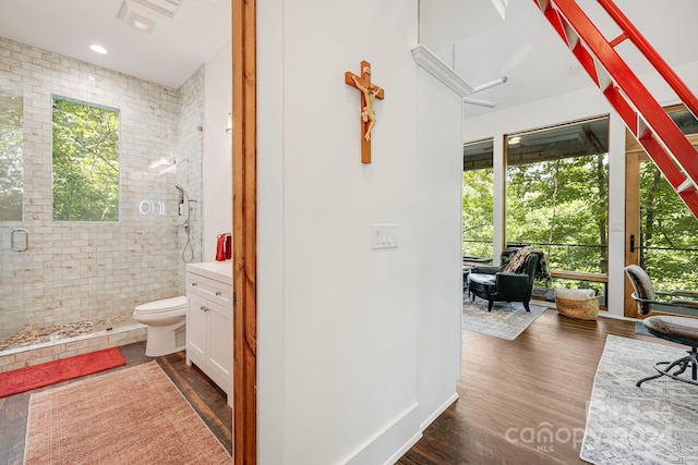 bathroom featuring hardwood / wood-style floors, walk in shower, toilet, and vanity