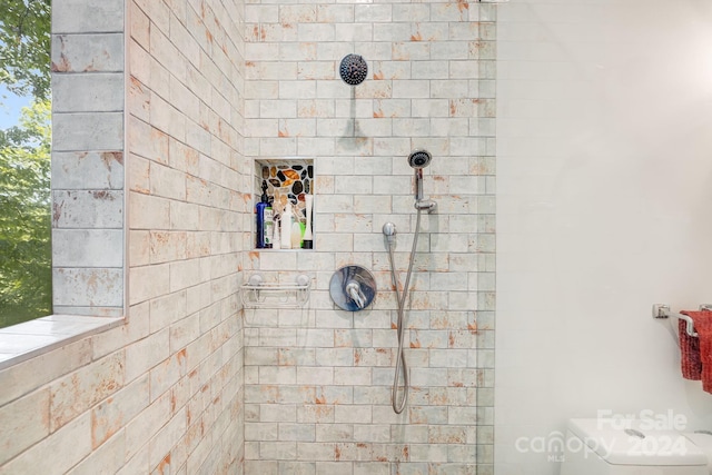 bathroom featuring toilet and a tile shower