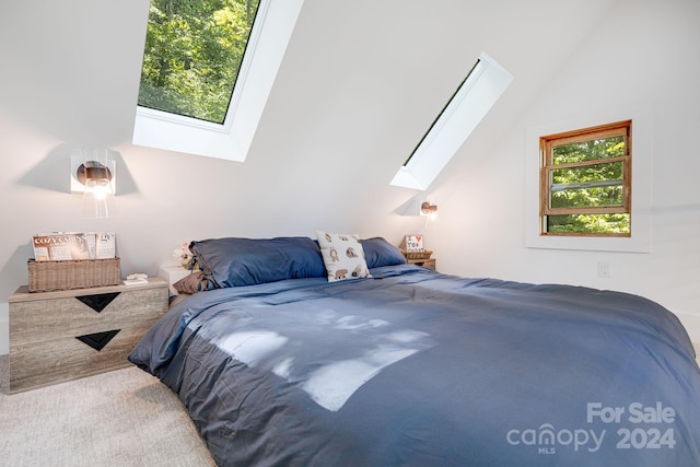 carpeted bedroom featuring lofted ceiling with skylight