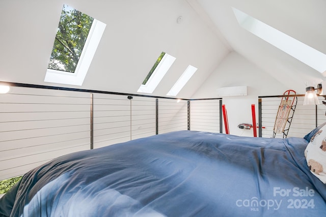 bedroom with vaulted ceiling with skylight and an AC wall unit