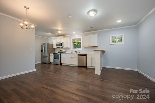 kitchen with appliances with stainless steel finishes, dark wood-type flooring, white cabinets, decorative light fixtures, and crown molding