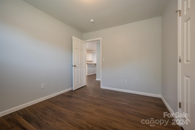 unfurnished bedroom with dark wood-type flooring