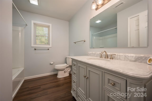 full bathroom with hardwood / wood-style flooring, vanity, toilet, and  shower combination