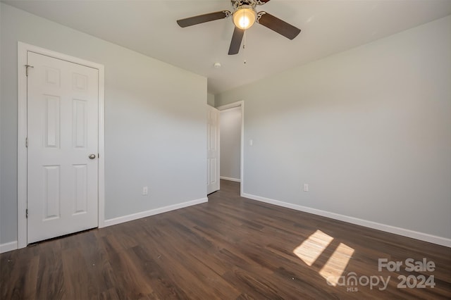 unfurnished bedroom featuring ceiling fan and dark wood-type flooring