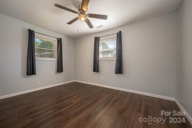 unfurnished room featuring plenty of natural light, ceiling fan, and dark hardwood / wood-style floors