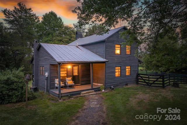 back house at dusk with a lawn