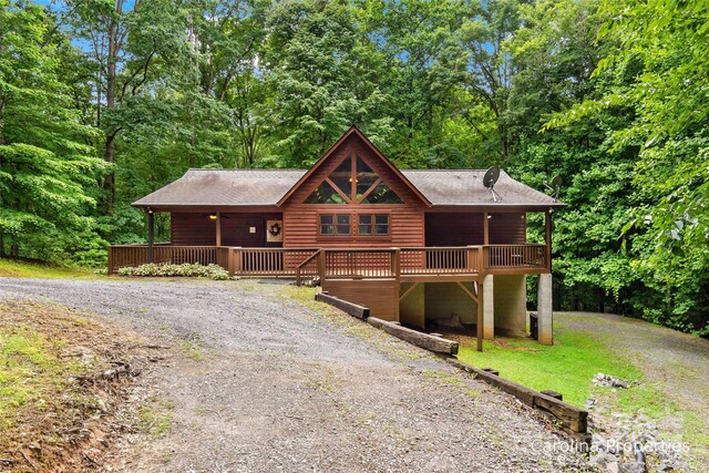 cabin featuring a deck and a front yard