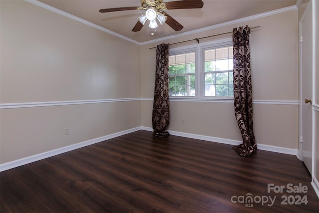 empty room featuring baseboards, ornamental molding, and dark wood-type flooring