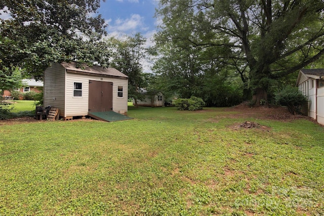 view of yard featuring a storage shed and an outbuilding