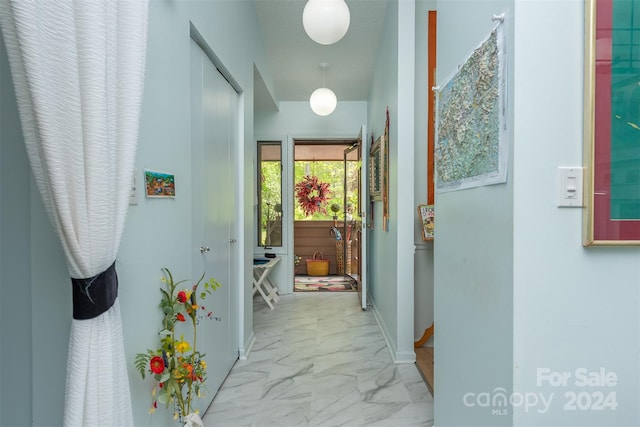 corridor with marble finish floor and baseboards