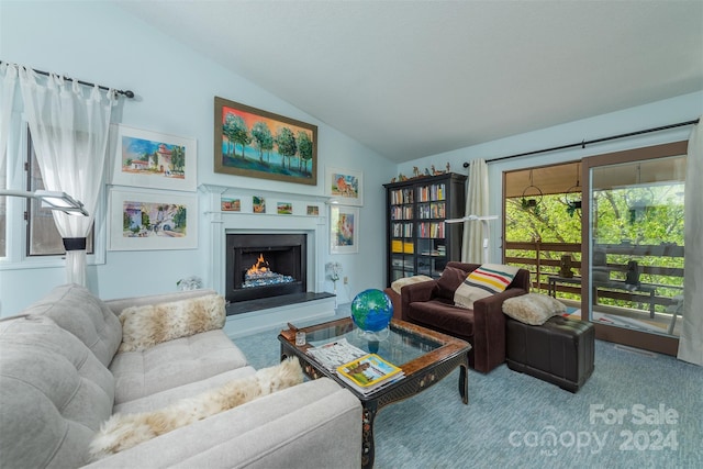 living room featuring vaulted ceiling, a warm lit fireplace, and carpet flooring